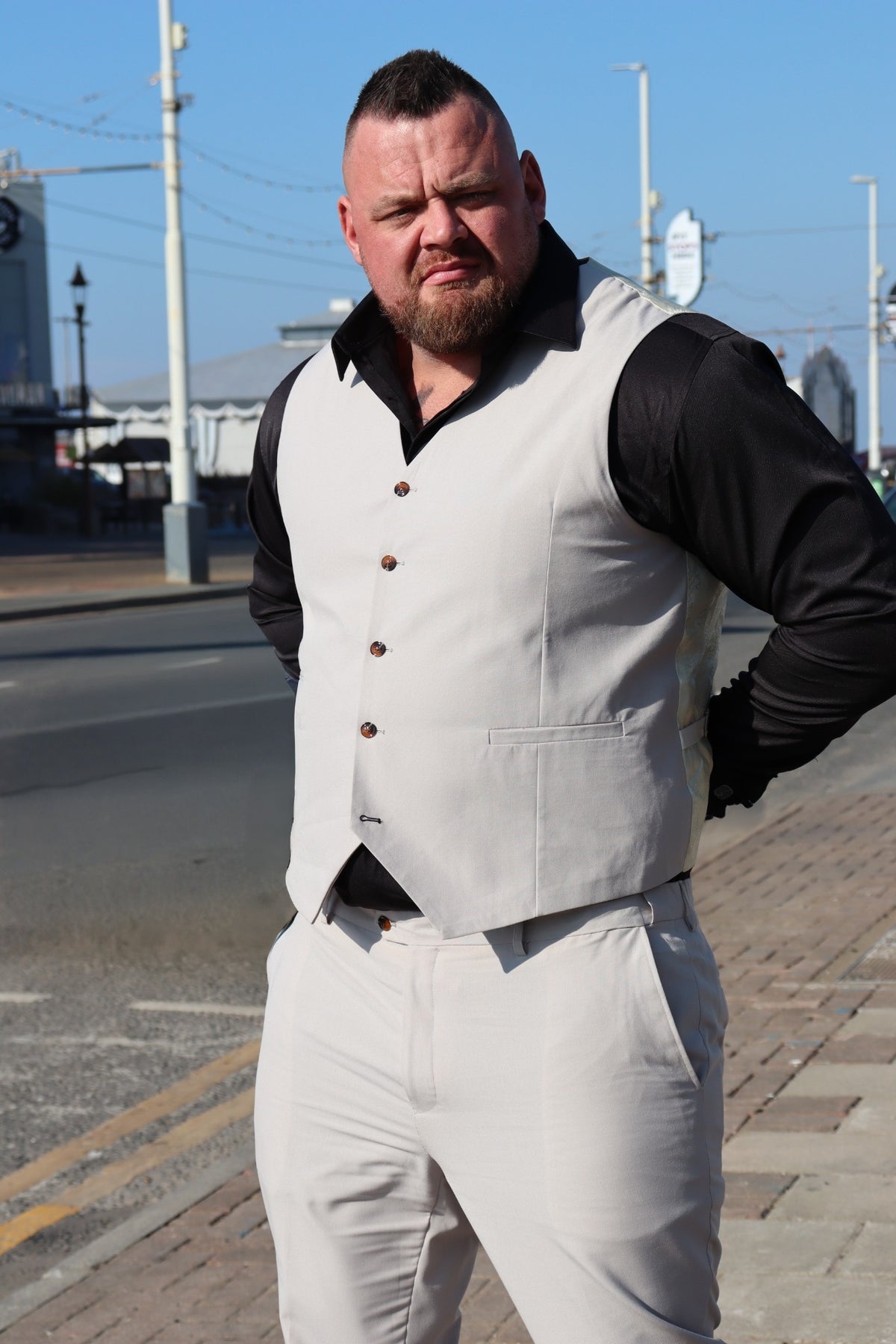 SUITBAE Kian Stone Three-Piece Suit — shown without the blazer to highlight the stone beige waistcoat with brown buttons and tailored stretch trousers. A flattering plus-size fit ideal for summer weddings and formal occasions.
