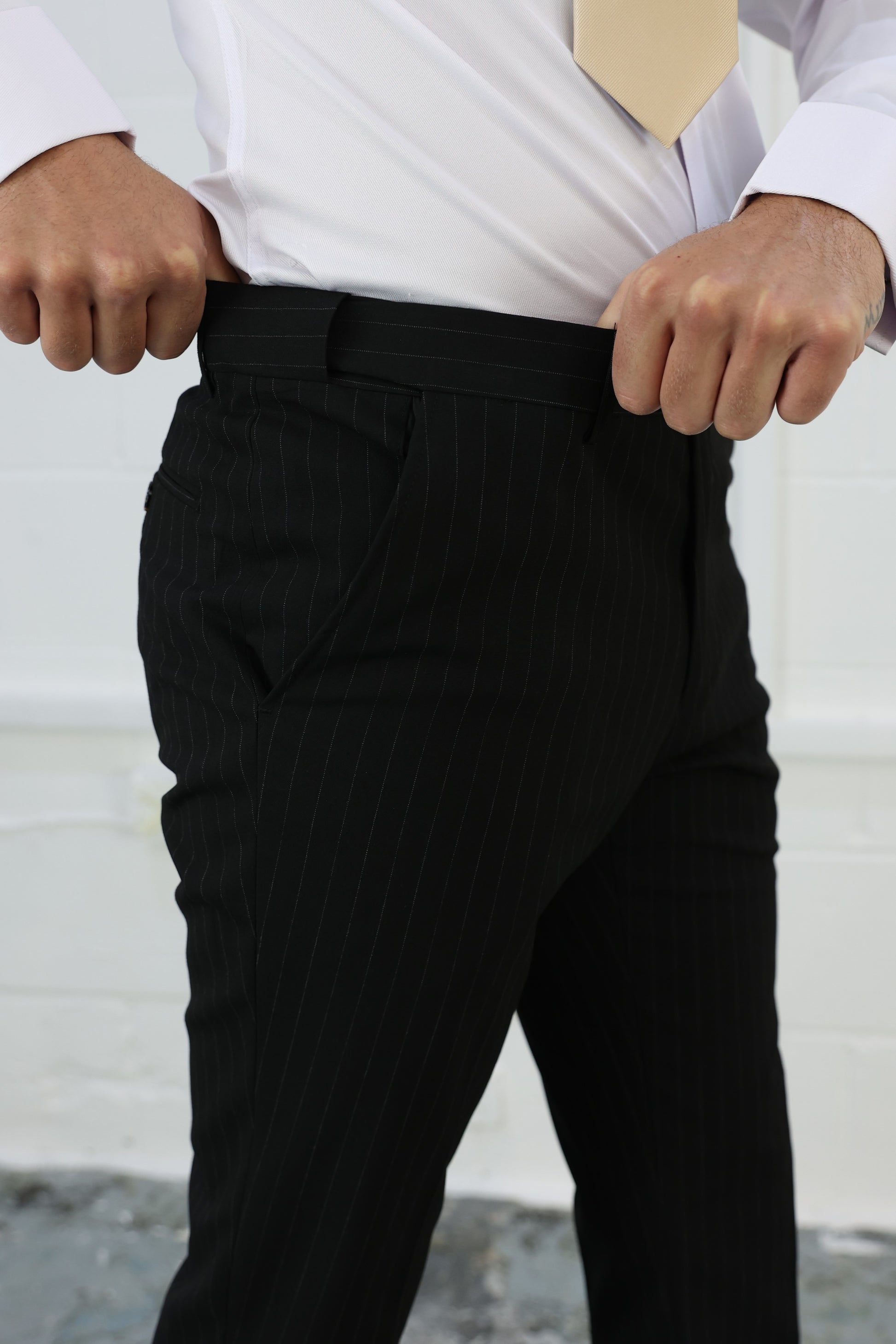 Close-up of Suitbae black pinstripe slim tailored fit tapered trousers, featuring an elastic waistband for added comfort and flexibility; designed to be sold individually for formal or smart-casual occasions.