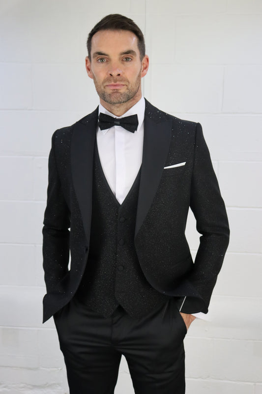 SUITBAE Sparkly Three Piece Tuxedo – black glitter tuxedo with satin peak lapel, matching waistcoat and tailored trousers. Styled with white dress shirt and black bow tie for a premium eveningwear look, perfect for black tie events, galas and weddings – available at SUITBAE Blackpool, Barnsley and shpxlxnx.top.