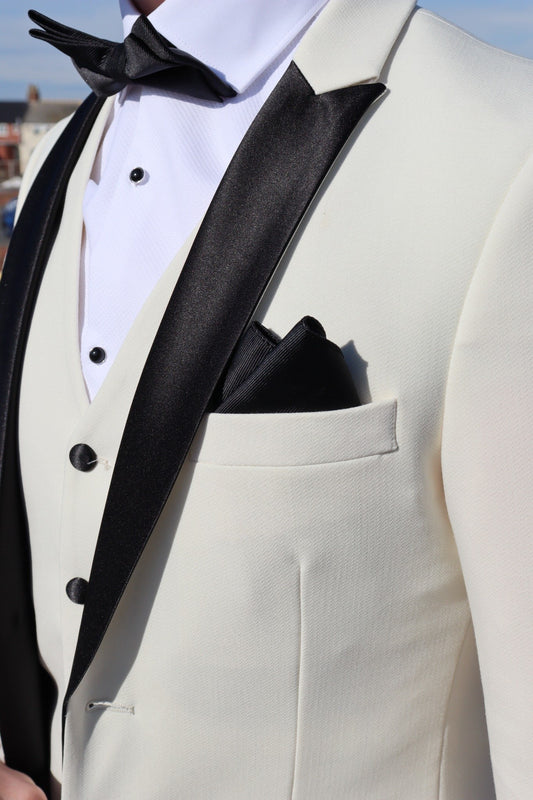 Close-up of the SUITBAE Diablo Ivory Three-Piece Tuxedo showing the black satin peak lapel, matching black buttons and pocket square — premium ivory tuxedo perfect for weddings, proms and black-tie occasions, available in plus sizes.
